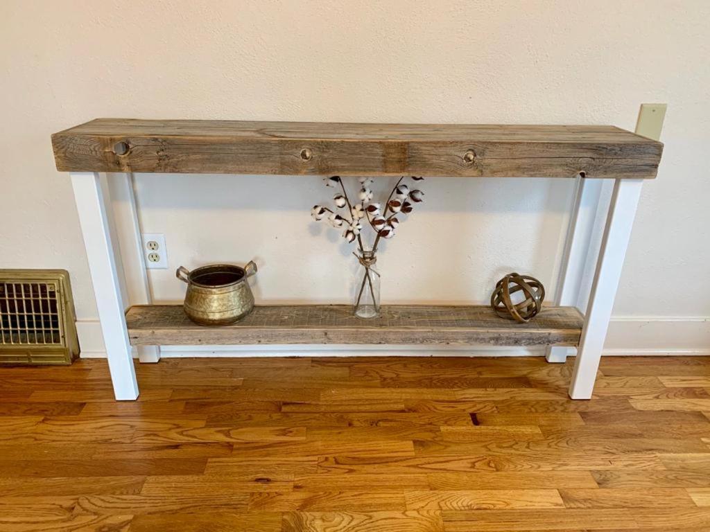 a console table with a vase of flowers on it at Riverpath Inn in Eugene
