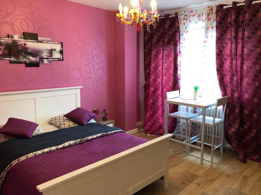 a bedroom with purple walls and a bed and a chandelier at Chambres privées Calais Ferry-Port-Place d&#39;armes in Calais