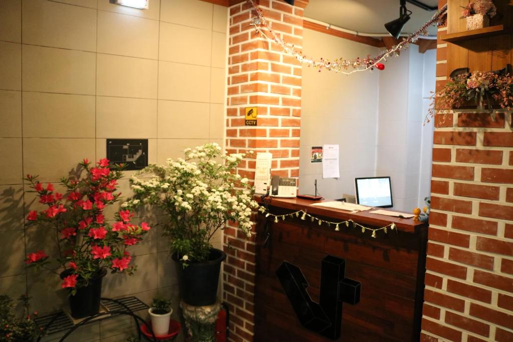 una oficina con flores y un escritorio con ordenador portátil en Dadareum Guesthouse en Seúl