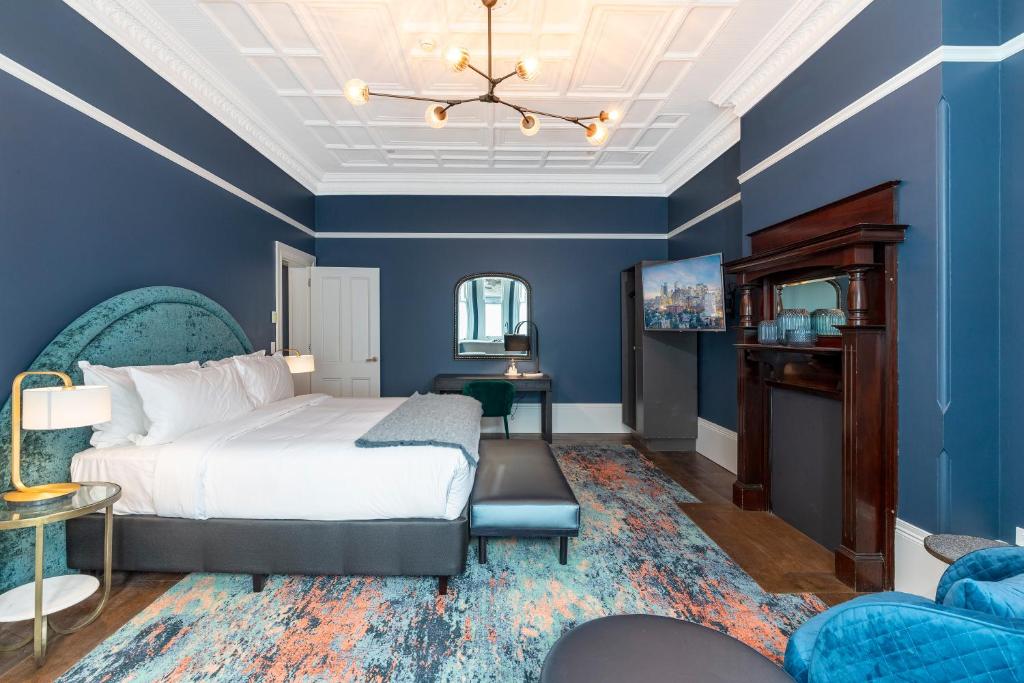 a bedroom with blue walls and a bed and a couch at The Albert Mosman in Sydney