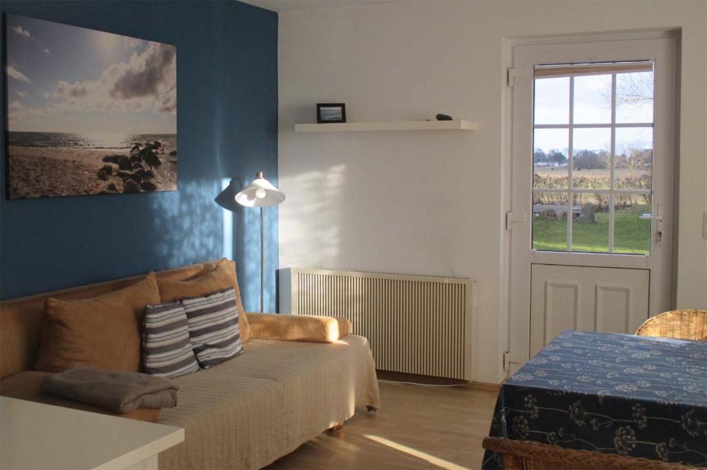 a living room with a couch and a window at Hof Faasel - Bauernhofurlaub an der Ostsee in Grömitz