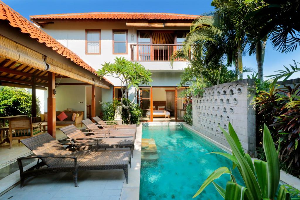 un patio con piscina e una casa di Aradhana Villas by Ekosistem a Canggu