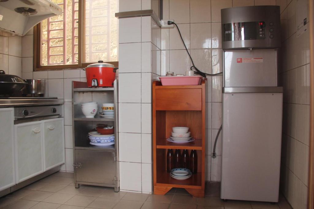 a kitchen with a refrigerator and a shelf with dishes at TopHome 9 in Jiufen