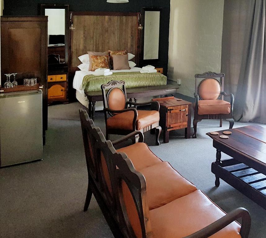 a bedroom with a bed and chairs and a table at Rustique Paris Guest House in Parys