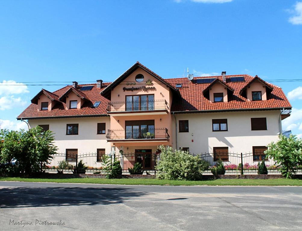 una casa grande con techo rojo en Pensjonat Korona, en Modrzyca