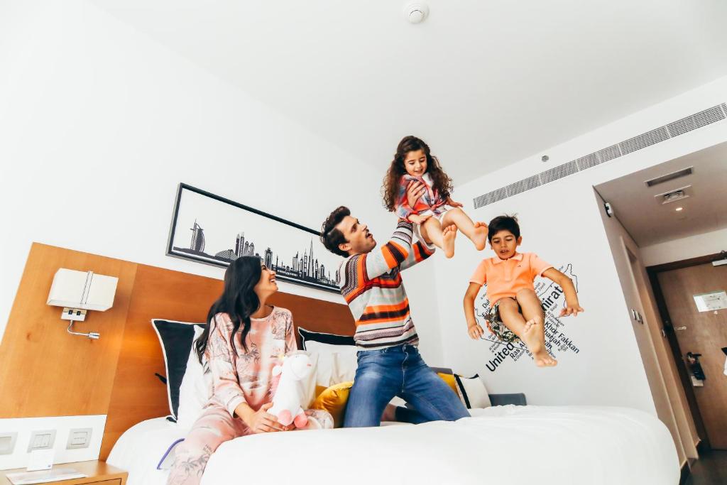 a group of people jumping on a bed at TRYP by Wyndham Dubai in Dubai