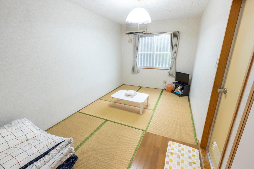 a room with a bed and a table on the floor at kamekamehouse in Tokashiki