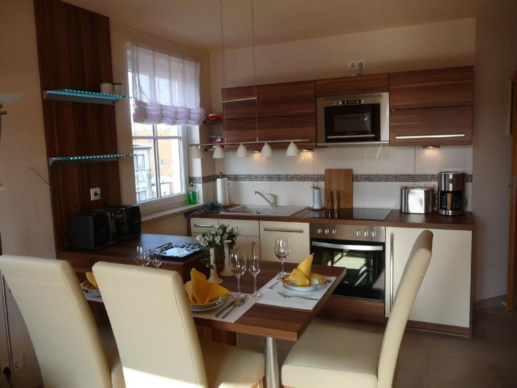 a kitchen with a wooden table with chairs and a dining room at Ferienwohnung Seeanemone I in Graal-Müritz