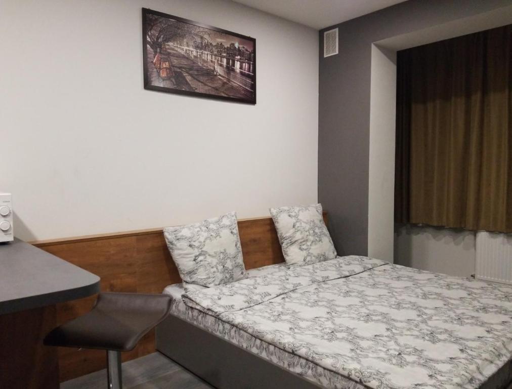 a small bedroom with a bed and a desk at Апарт-сервис s1 in Uzhhorod