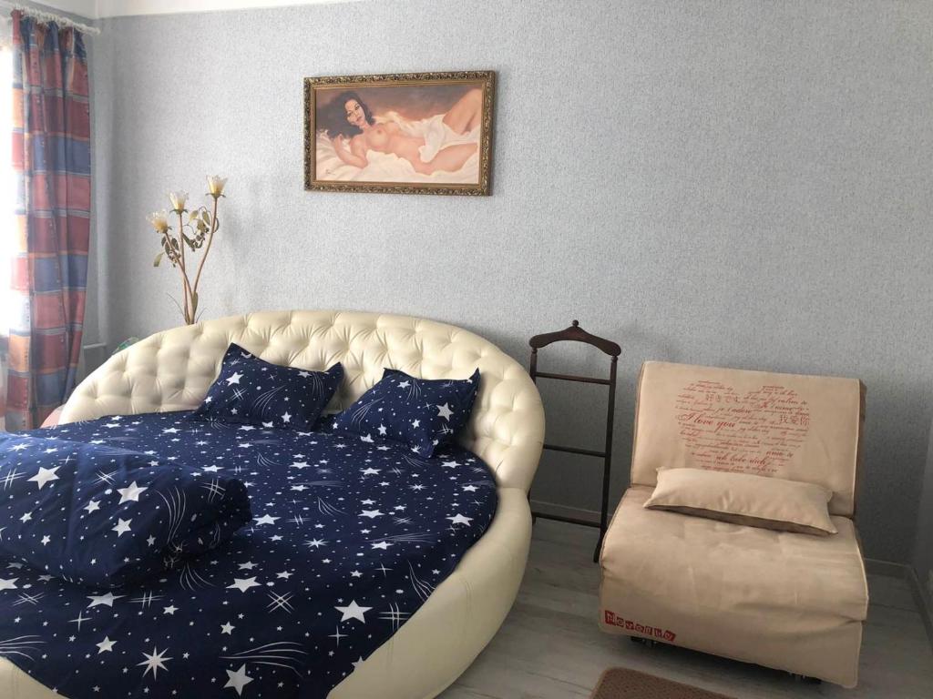 um quarto com uma cama e uma cadeira em Апартаменты Дворец Украины с круглой кроватью em Kiev