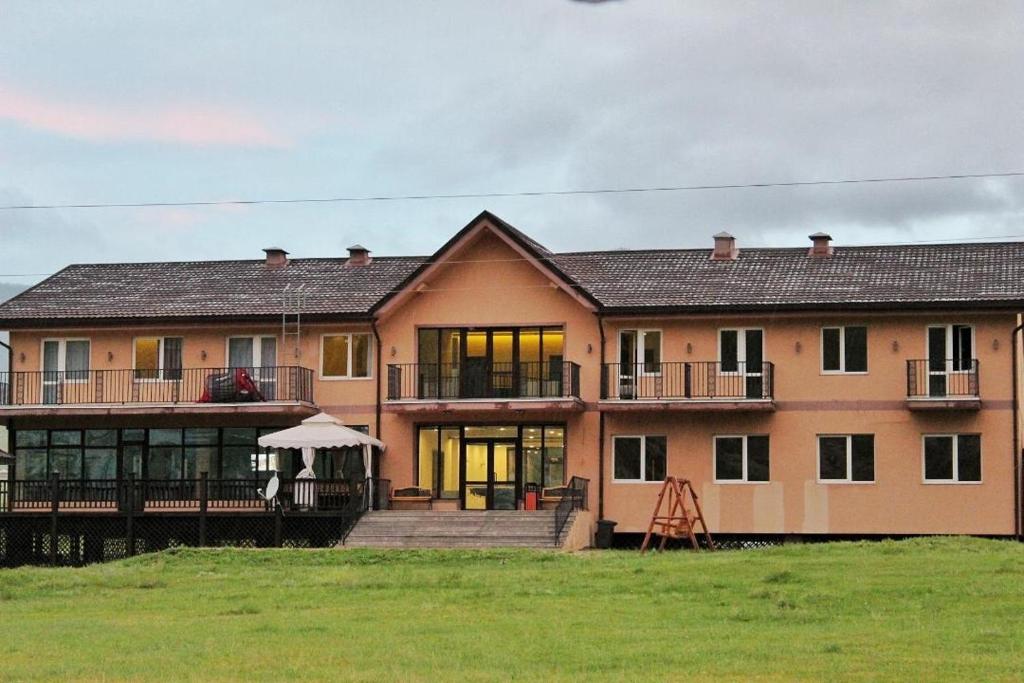 une grande maison avec une pelouse devant elle dans l'établissement Takhi Resort Terelj, à Yoliin Hural