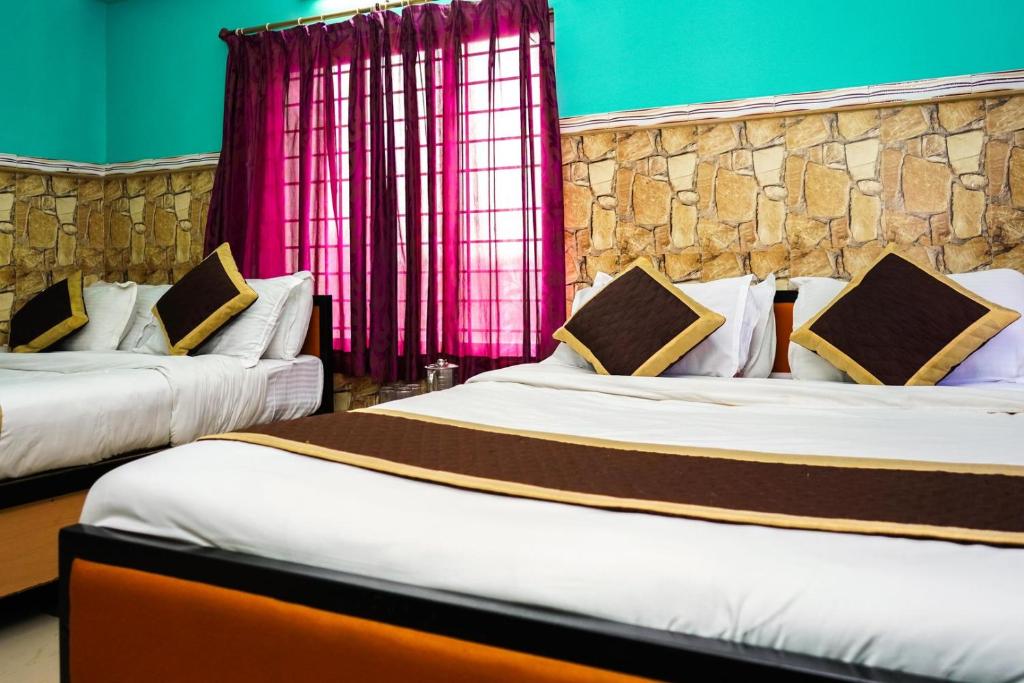Postel nebo postele na pokoji v ubytování Tirupati Lodge NJP