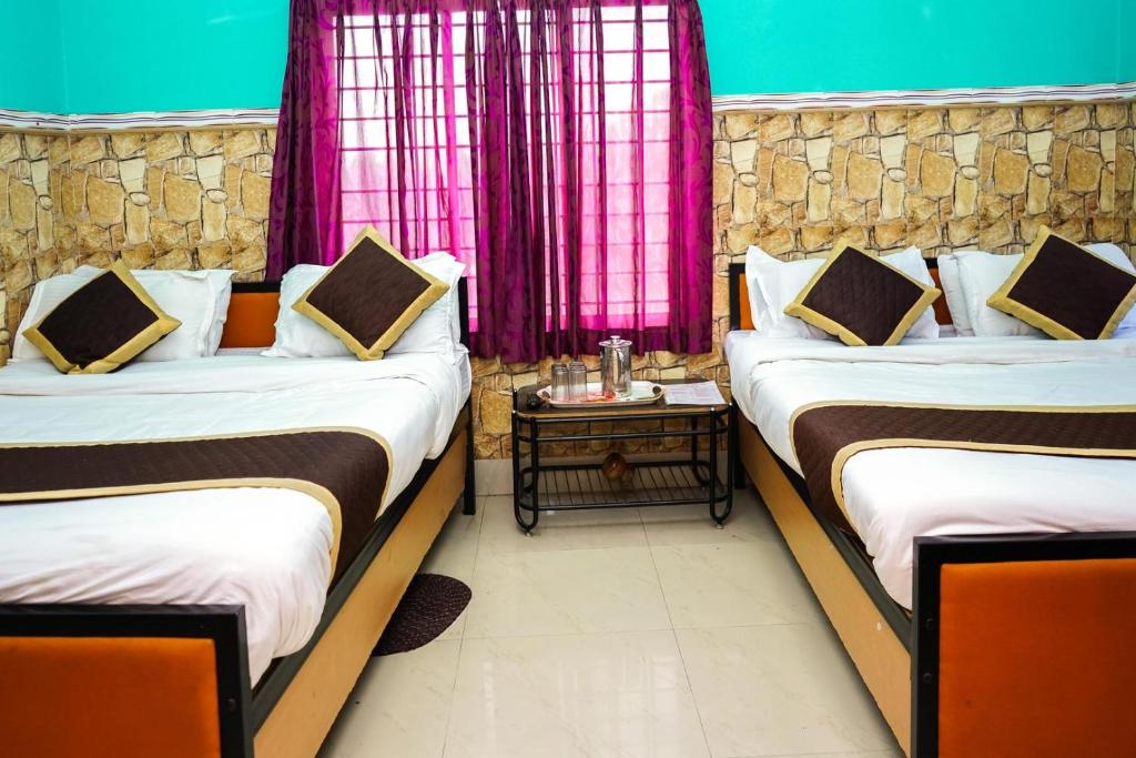 Postel nebo postele na pokoji v ubytování Tirupati Lodge NJP