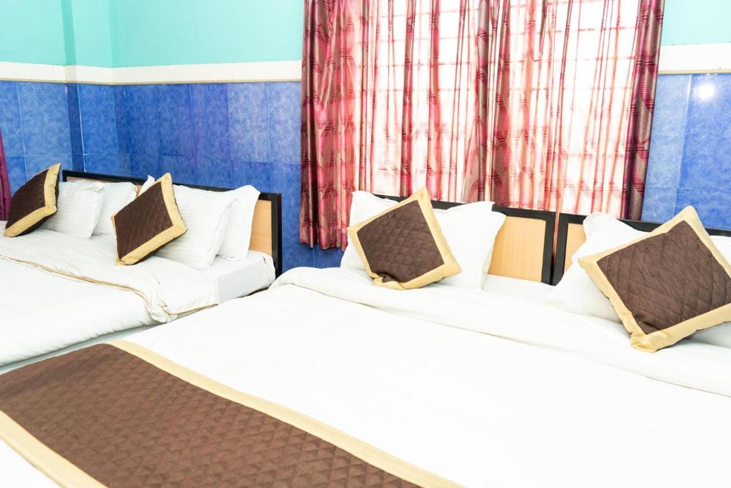 Postel nebo postele na pokoji v ubytování Tirupati Lodge NJP