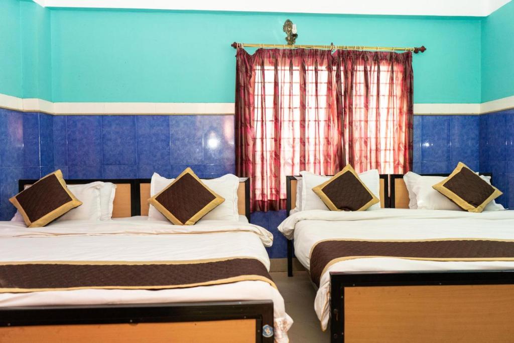 Postel nebo postele na pokoji v ubytování Tirupati Lodge NJP