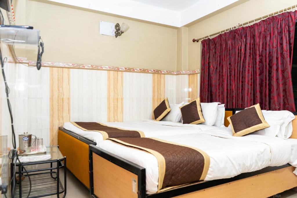 Postel nebo postele na pokoji v ubytování Tirupati Lodge NJP