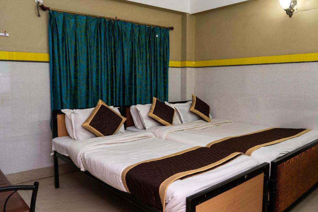 Postel nebo postele na pokoji v ubytování Tirupati Lodge NJP