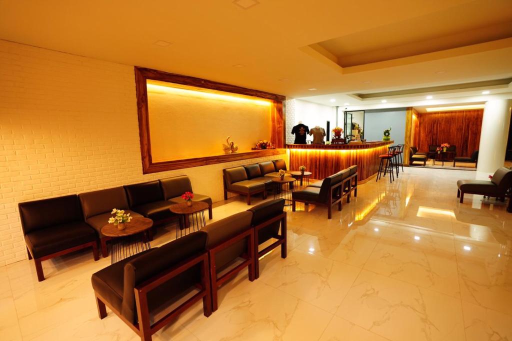 eine Lobby mit Sofas, Tischen und einer Bar in der Unterkunft Windsor Hotel in Nakhon Phanom