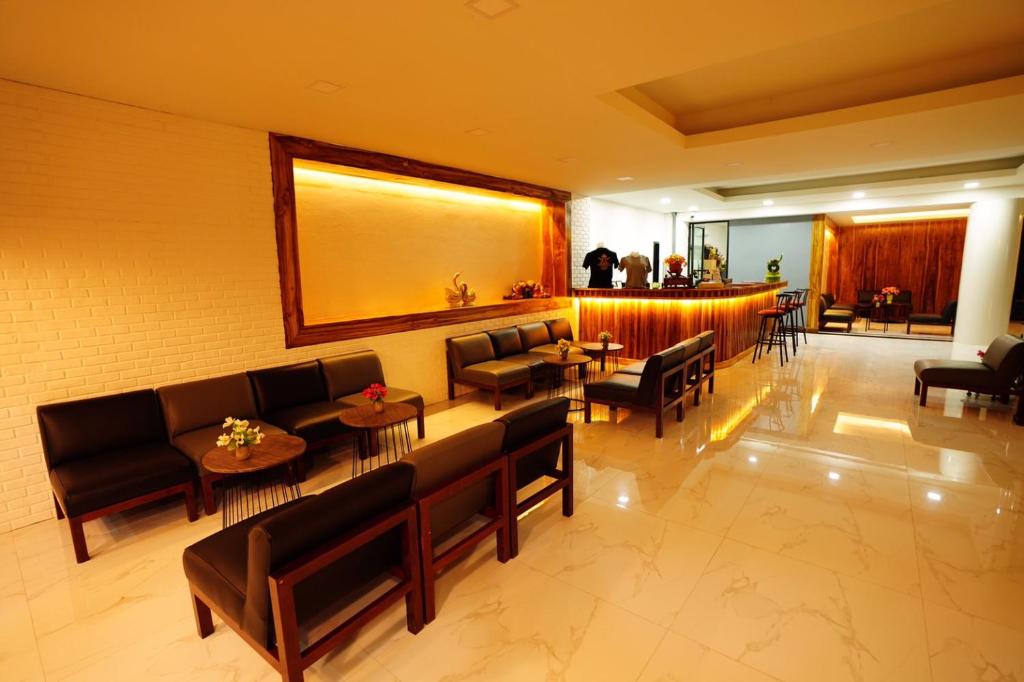 a lobby with couches and tables and a bar at Windsor Hotel in Nakhon Phanom