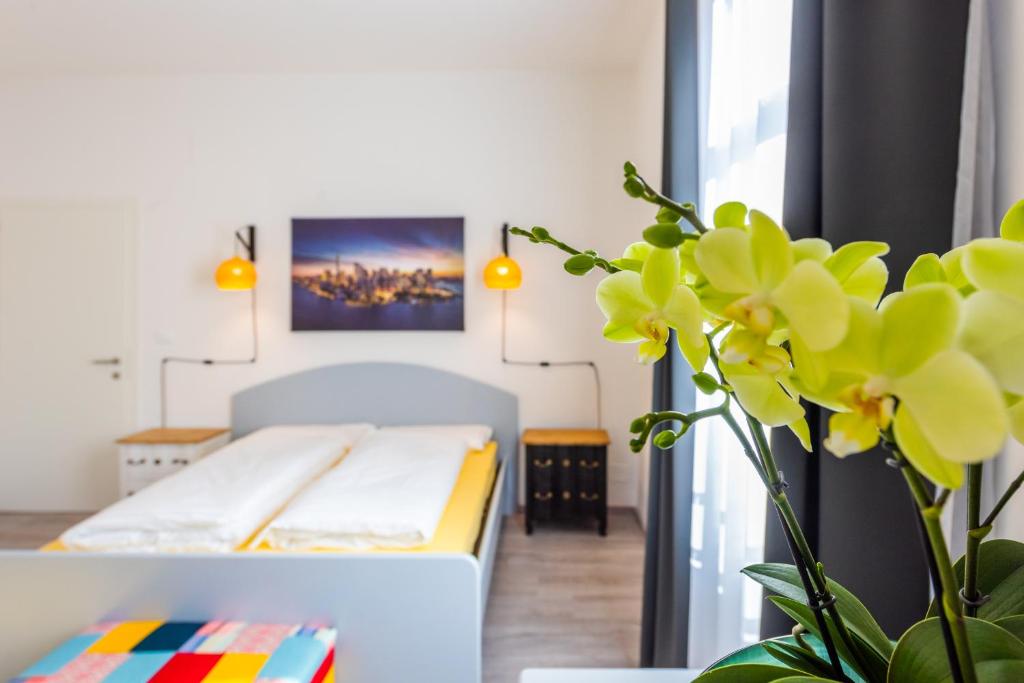 a living room with a bed and a plant at Lara's Guesthouse in Merano