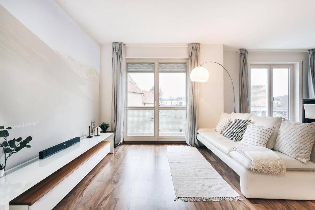 - un salon avec un canapé blanc et une fenêtre dans l'établissement Modernes Apartment mit Heimkino in Dresden, à Dresde