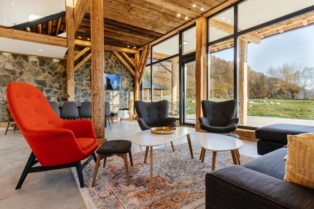 a living room with a couch and chairs and a table at Loft Chalet in Gura Humorului