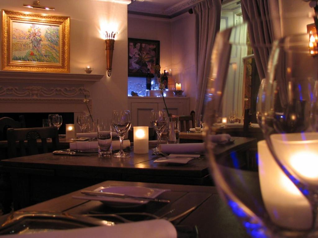 a restaurant with a table with wine glasses and candles at The Frenchgate Restaurant & Hotel in Richmond