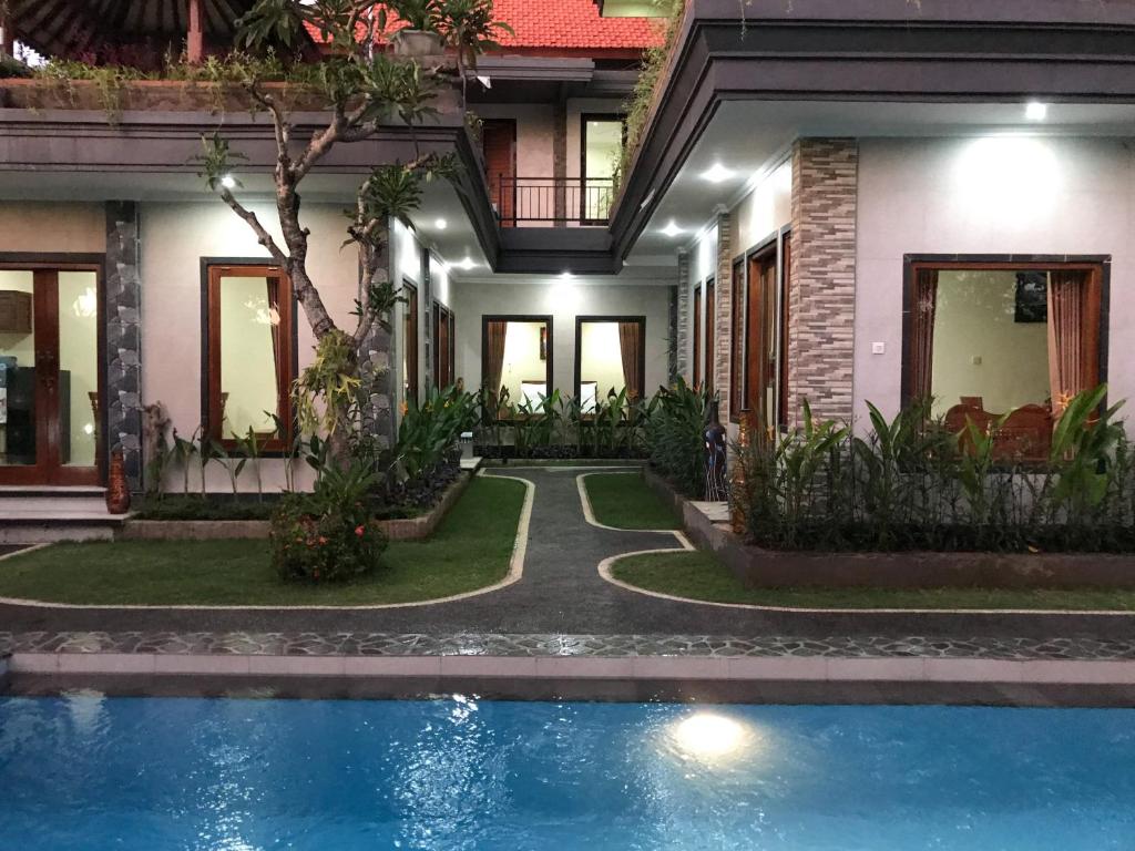 a house with a swimming pool in front of a house at Villa Dira Ubud in Ubud