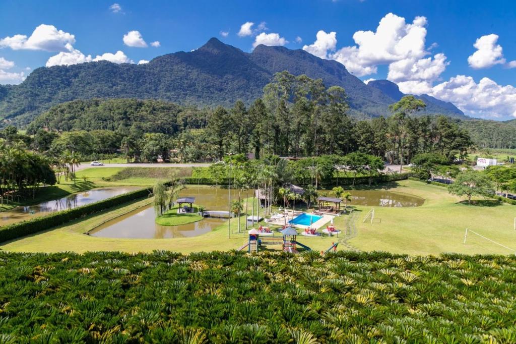 a view of a golf course with mountains in the background at Tureck Garten Hotel in Corupá