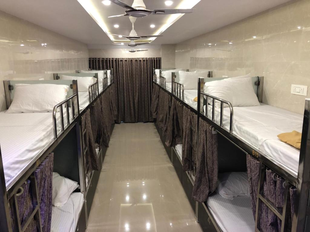 rząd łóżek piętrowych w pokoju w obiekcie ELLIOTT INN A.C DORMITORY w Bombaju