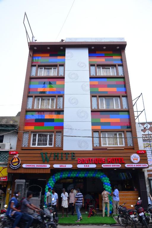 un edificio multicolor con gente parada frente a él en Hotel White Boutique, en Pondicherry