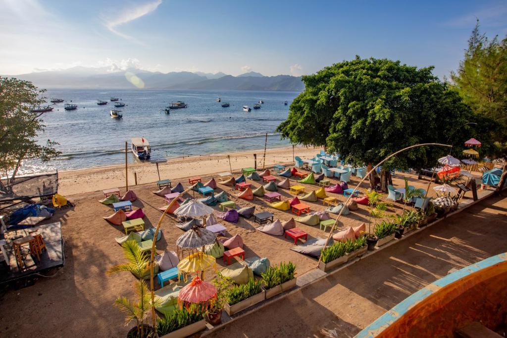 una vista dall'alto di una spiaggia con sedie e ombrelloni di Gili Sands Hotel & Bar a Gili Trawangan