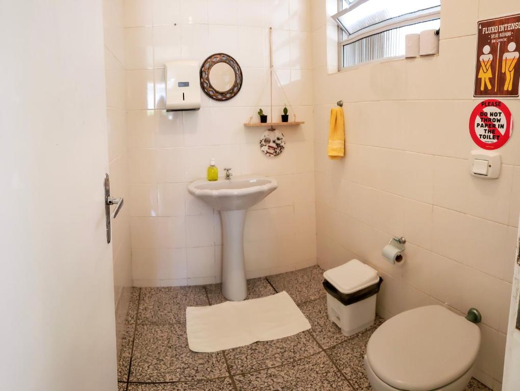 a bathroom with a toilet and a sink at Pequi hostel in Florianópolis