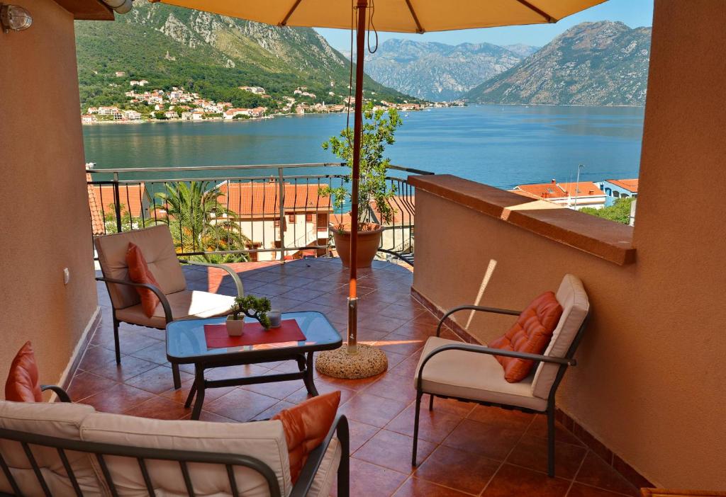 a balcony with chairs and a table and an umbrella at Villa Sofia in Kotor