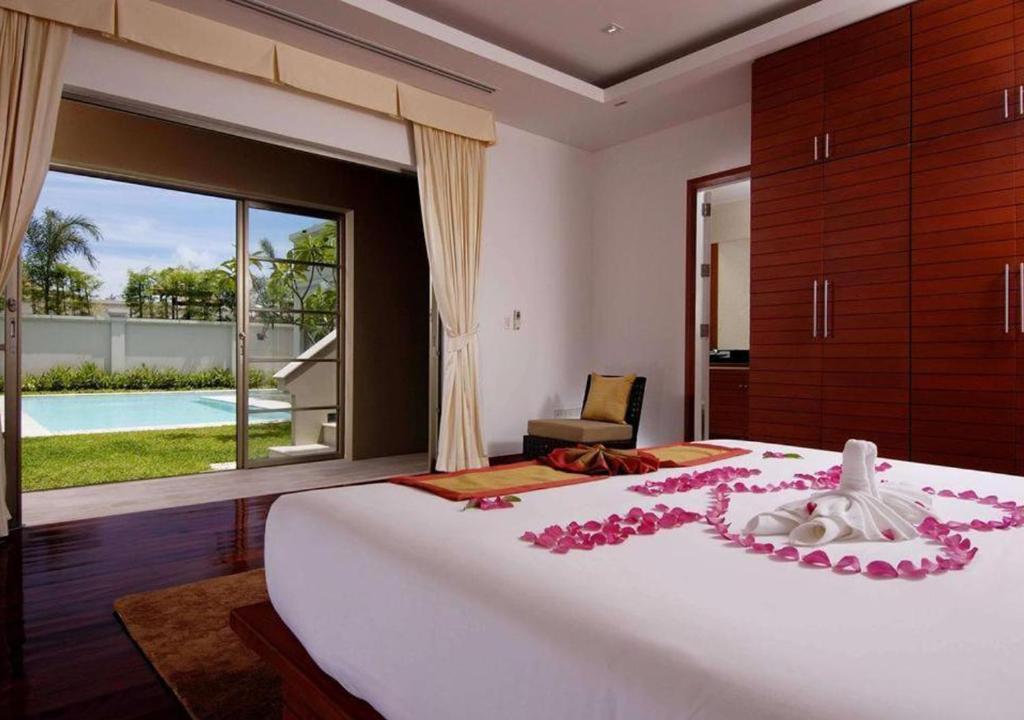 バンタオビーチにあるThe Residence Bantao Villa unit 121のベッドルーム1室(ピンクの花が咲く大型ベッド1台付)