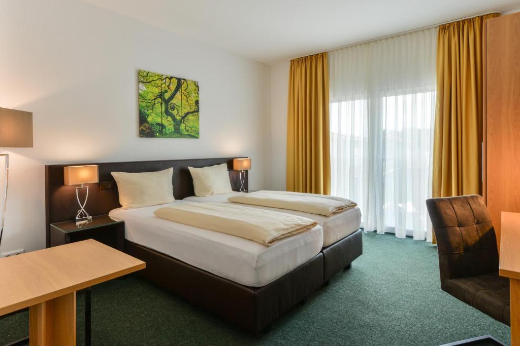 マルツリンクにあるラントガストホフ ナガールの大きなベッドとデスクが備わるホテルルームです。