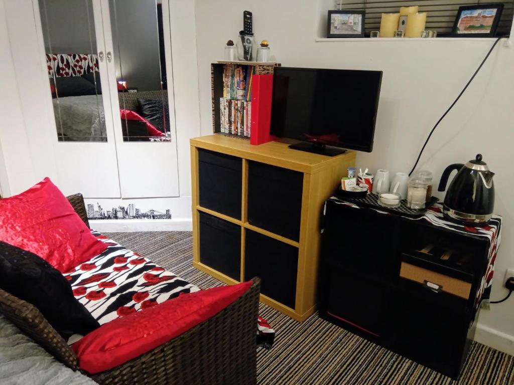 a living room with a tv and a couch and a tv stand at Oxford Road in Macclesfield