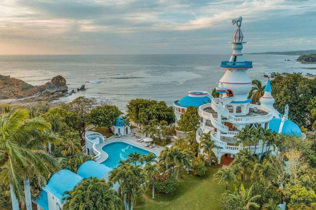 an aerial view of a resort with a pool and a lighthouse at Nosara Beach Hotel in Nosara