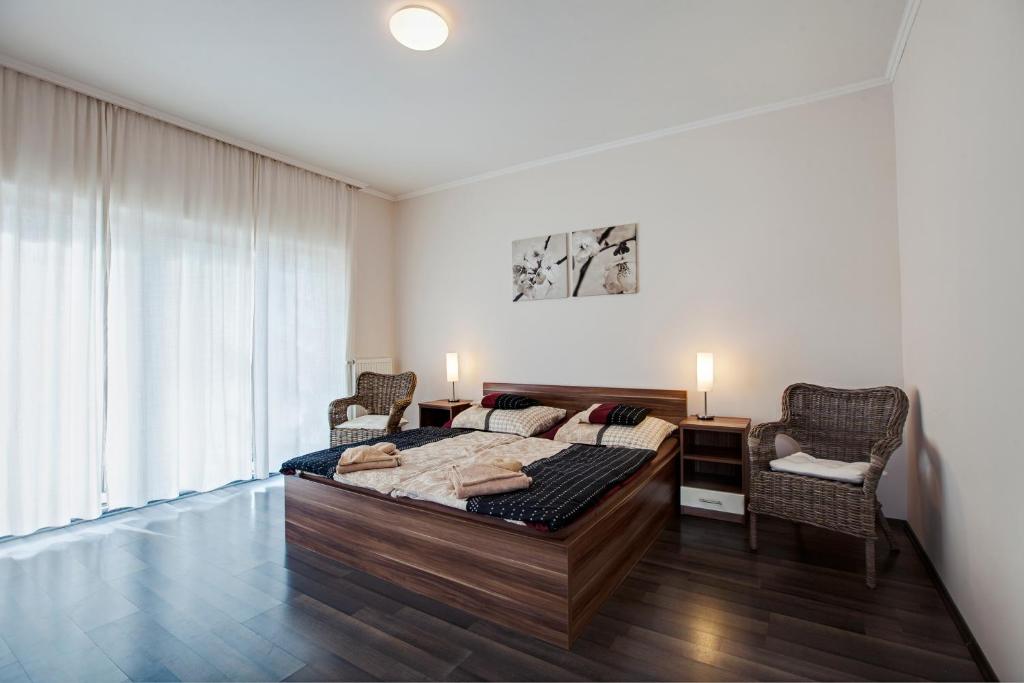 a bedroom with a bed and a desk and chairs at Kocsis Apartman és Camping in Mosonmagyaróvár
