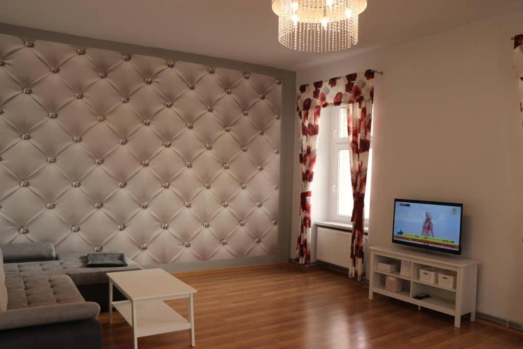 a living room with a couch and a tv at Apartament Family in Tarnowskie Góry