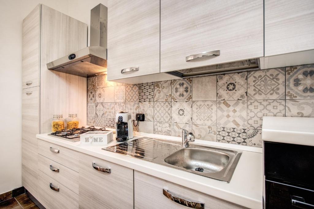 uma cozinha com um lavatório e um fogão em Laura luxury apartment in the center Rome em Roma