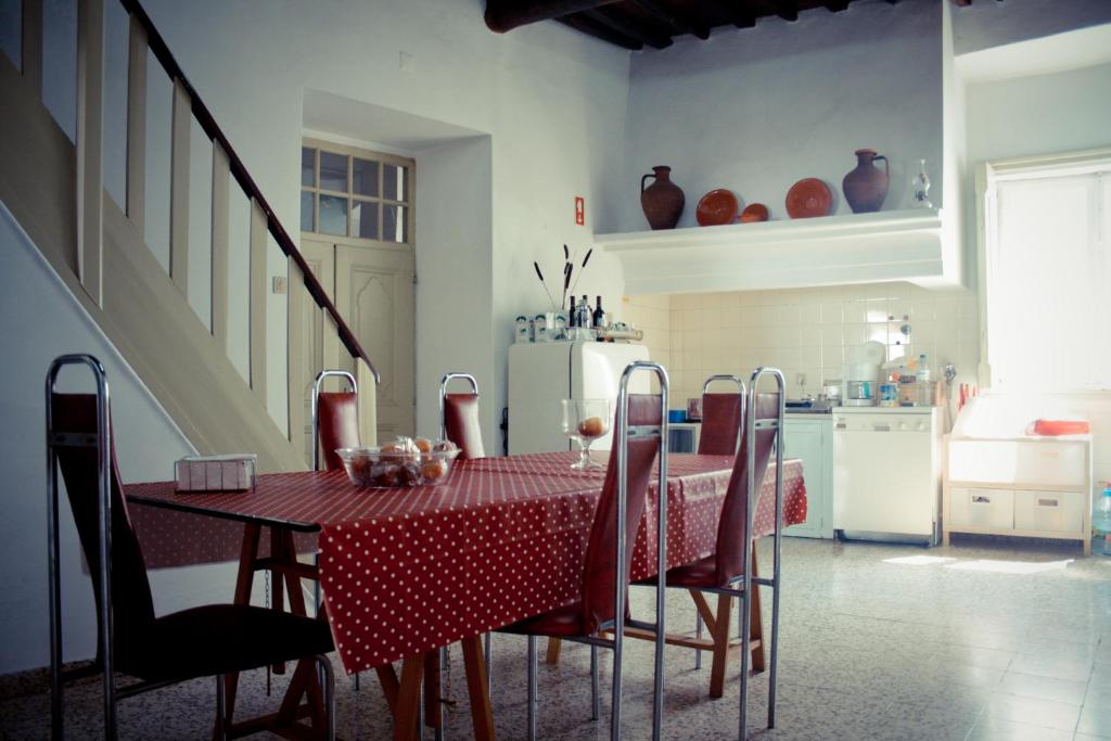 a kitchen with a table with a red and white table cloth at Hostel Portalegre in Portalegre