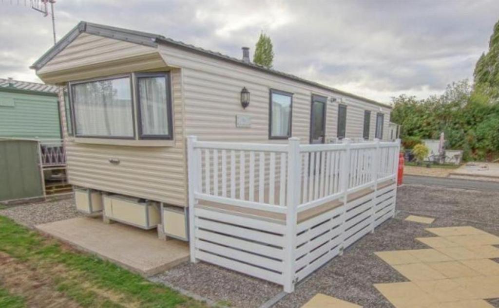 a tiny house with a white fence in a yard at Rio Stratford-Upon-Avon in Stratford-upon-Avon