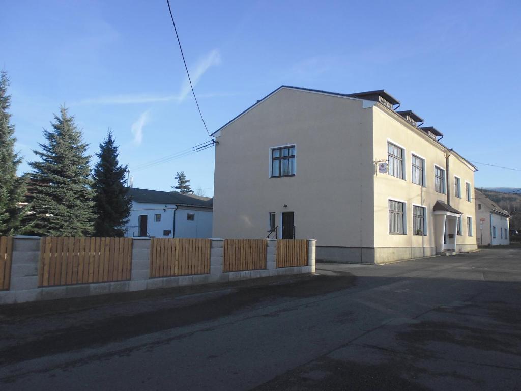 a white house with a fence in front of it at bike-Hotel Měděnec in Nové Město pod Smrkem