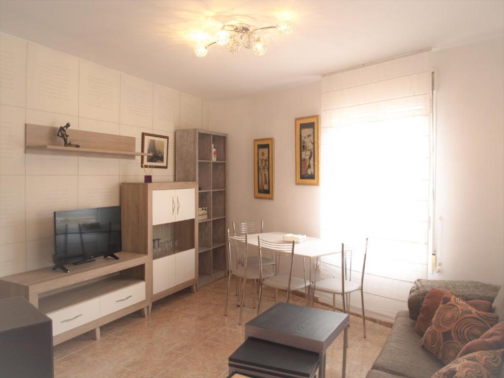a living room with a couch and a table with a tv at CASA KALIMERA in Cuenca
