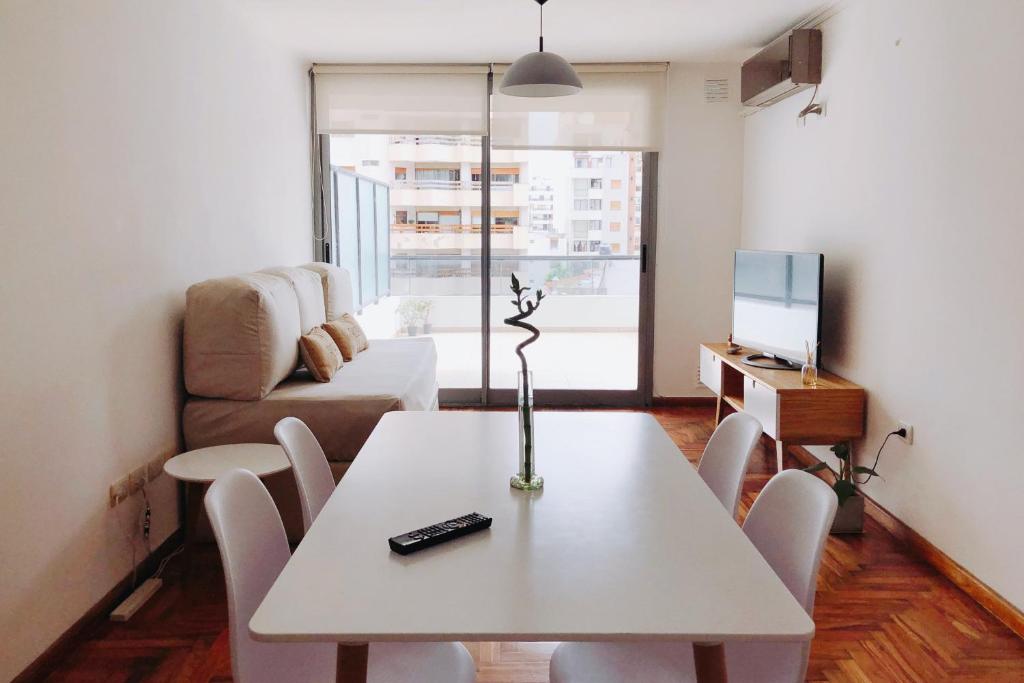un soggiorno con tavolo e divano di Ayres de Córdoba, Gran Terraza, Excelente Ubicación a Córdoba