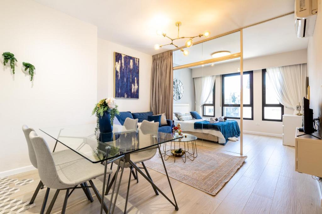 - un salon avec une table en verre et un canapé bleu dans l'établissement King David 19 Apartment, à Jérusalem