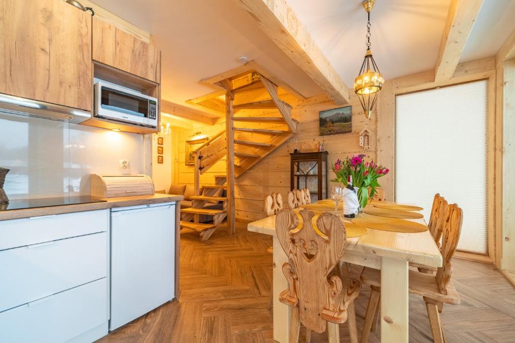 a kitchen and dining room with a table and chairs at Przedsionek Tatr in Zakopane