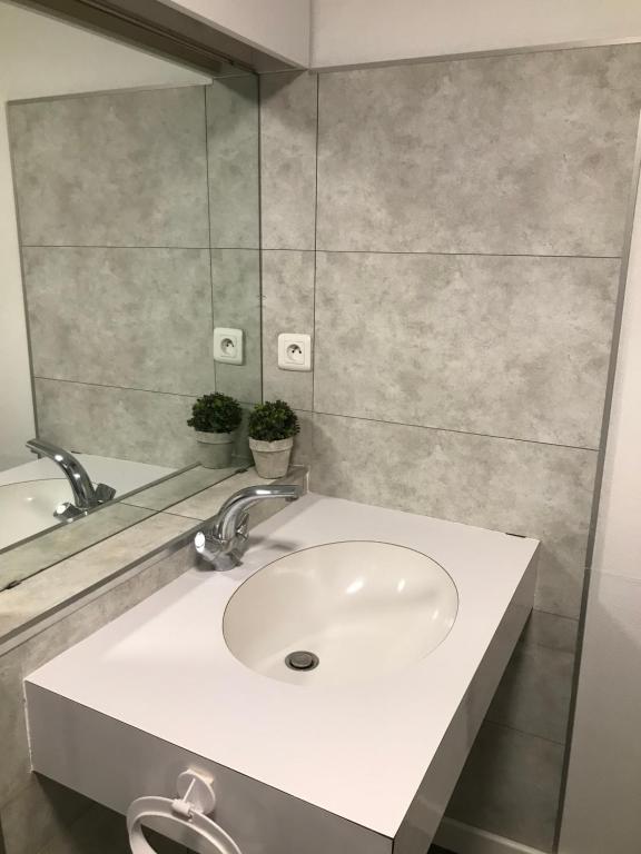 ein Badezimmer mit einem weißen Waschbecken und einem Spiegel in der Unterkunft Studio Meublé Vue Mer in Le Havre