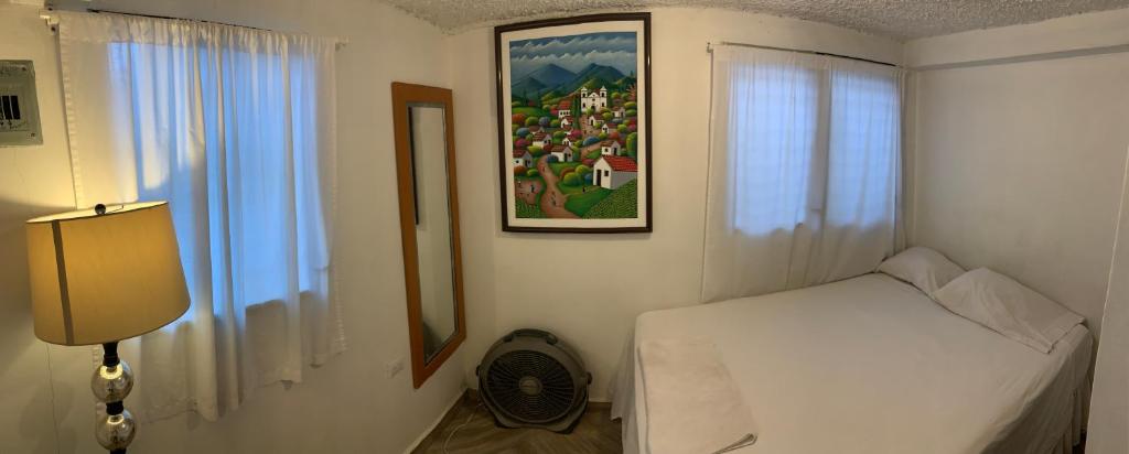 a bedroom with a bed and a painting on the wall at Palmira Hostel in Tegucigalpa